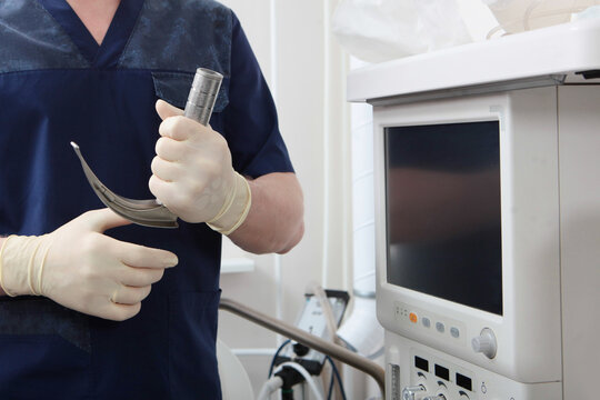 Laryngoscope for tracheal intubation in hands of an anesthesiologist. General anesthesia before surgery. Saving life. Concept of healthcare.