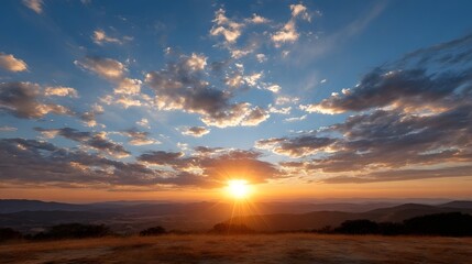 Fototapeta premium A breathtaking view of dramatic clouds and vibrant warm colors illuminating an open landscape at sunrise or sunset