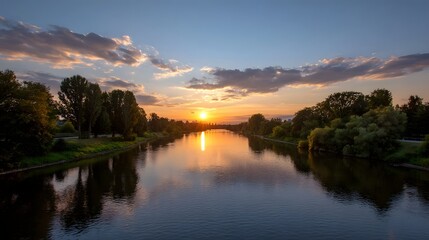 Obraz premium A breathtaking sunset casting a warm golden glow across the tranquil river perfectly mirrored by the calm waters and framed by lush foliage