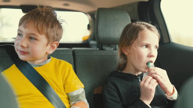 Kids in car enjoy candy while traveling during the day