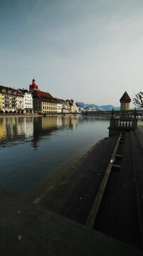 LUCERNE, SWITZERLAND - MARCH 06, 2026: Shot of Reuss river bank, historic Town Hall and Chapel Bridge in Lucerne, Switzerland