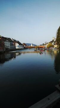 Panning shot of Reuss river, historic Spreuer Bridge and Musegg Wall towers, Lucerne, Switzerland