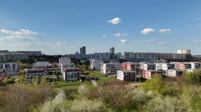 Panoramic drone view of Prague 4 residential district in spring. aerial shot captures the diverse architecture of the Prague blooming spring trees, and walking paths weave through the urban landscape