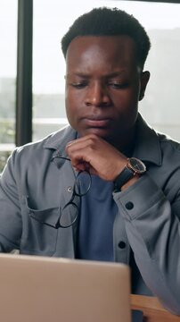 Frustrated, glasses or black man with laptop in office, negative project feedback or campaign reviews. Window, disappointed or marketer with pc to monitor launch, specs or audience comment reflection