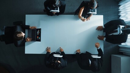 Naklejka premium Top down aerial view of diverse data analysts wearing VR headset and stand around table while using hand gestures to manipulate the data streamed live from executive manager's laptop. Directorate.