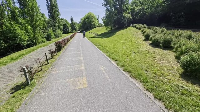 POV cycling on park path, first-person bike ride in nature