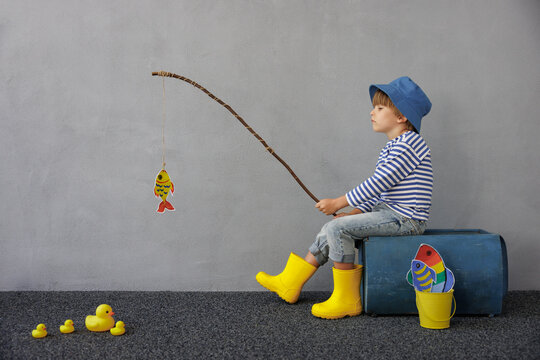 Happy child playing indoor. Kid enjoying a fishing trip. Little boy having fun at home