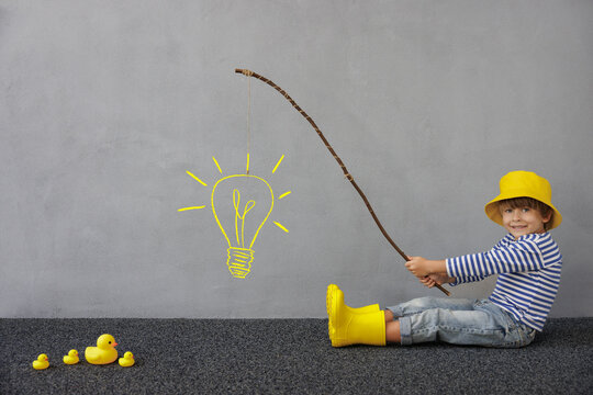 Idea! Happy child playing indoor. Kid enjoying a fishing trip. Little boy having fun at home