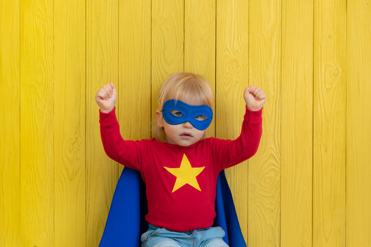 Little boy dressed as a superhero having fun at home