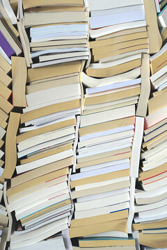 Texture de livres d'occasion empil&eacute;s de mani&egrave;re serr&eacute;e, vue en gros plan sur les tranches et les pages pour un effet abstrait et litt&eacute;raire