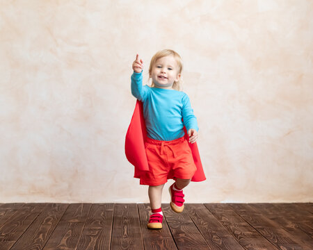 Little boy dressed as a superhero having fun at home