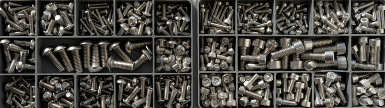 Organized fasteners assortment in plastic box, top view background