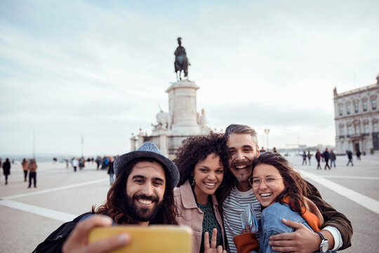 Happy friends taking selfie at praca do comercio, lisbon