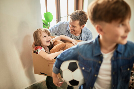 Father with children playing during moving day at home