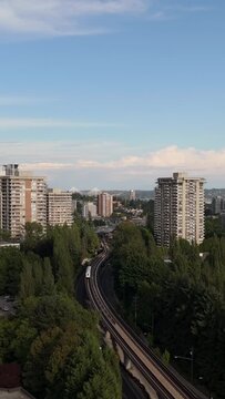 Elevated Skytrain Glides Through Burnaby's Green Urban Landscape in Vancouver, British Columbia, Canada