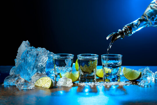 The tequila is poured from the bottle into shot glasses.