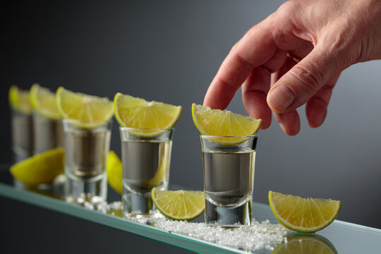 Tequila shots with salt and lime slices.