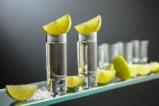 Gold tequila shots with salt and lime slices.