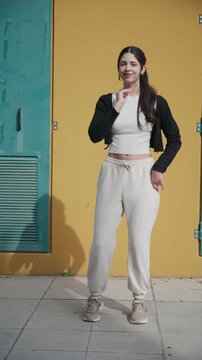 Energetic woman performing afrobeat hip hop dance routine outdoors