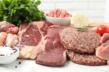 Fototapeta premium Different raw meat products, spices and tomato on table, closeup