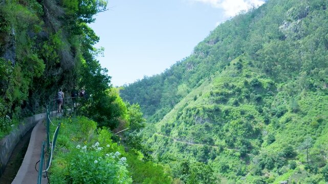 People walking along a levada trail in madeira, portugal