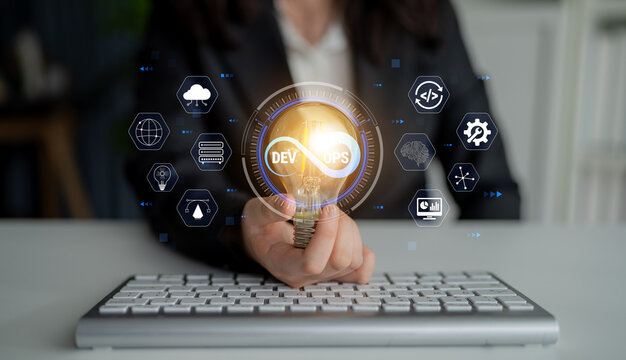 Business Professional Holding Light Bulb Symbolizing Innovation and Development in Technology with Digital Icons and Keyboard in the Background Quark.