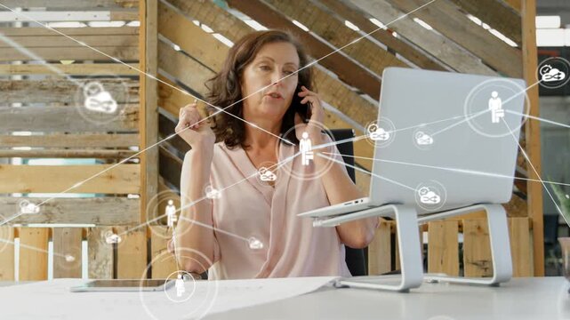 Woman speaking on phone while laptop glance triggers network icons expanding, visualizing teamwork