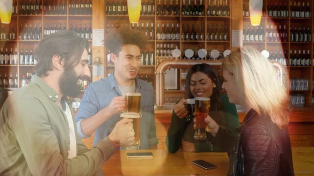 Bearded man offering beer mug in taproom, friends clinking glasses toasting near bottles and phone