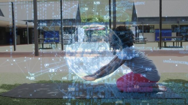 Female child kneeling on yoga mat following health cue, reaching digital globe and deepening pose