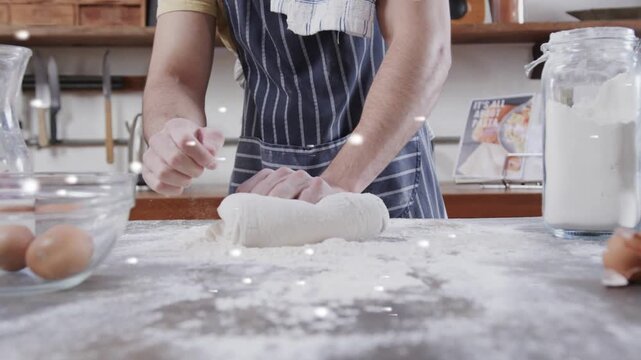 Male baker touching dough, pressing rolling on counter, bokeh tracking hands showing baking tip