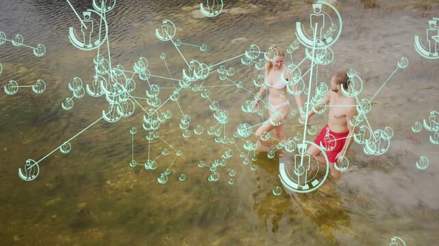 Couple stepping into shallow water, AR overlay clustering near feet with lit nodes mapping movement