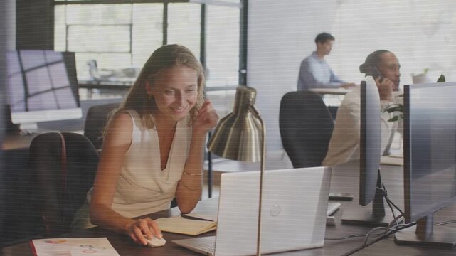 Female employee reaching papers then using mouse, scanning laptop, smiling, completing office task
