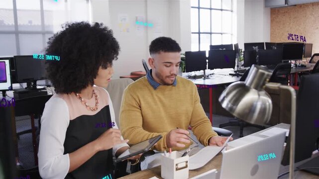 Woman bringing tablet forward, man marking documents and writing, both finalizing business report