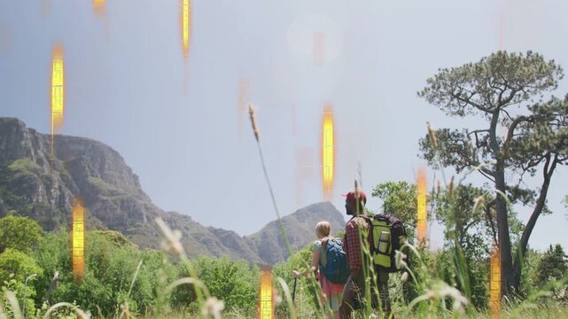 Woman hiker moving toward peaks outdoors while golden bars falling, causing advance, man looking up