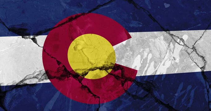 A panning video of a cracked wall with The colorado state flag of the United States of America