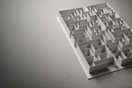 Paper labyrinth on a gray background. Space for text.