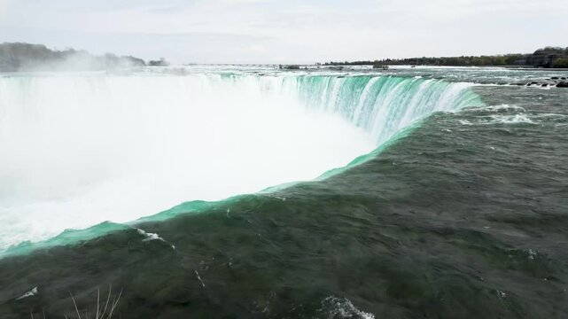 Niagara Falls waterfall cascading over rocky cliff edge with powerful flowing water motion