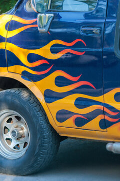 Car with flame design paint parked on street