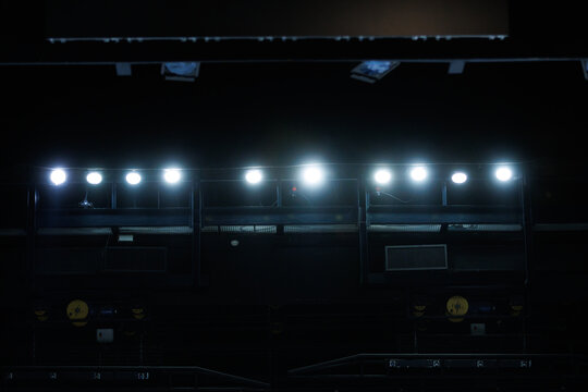 Bright lights shine down on an empty stage in a theater during nighttime hours