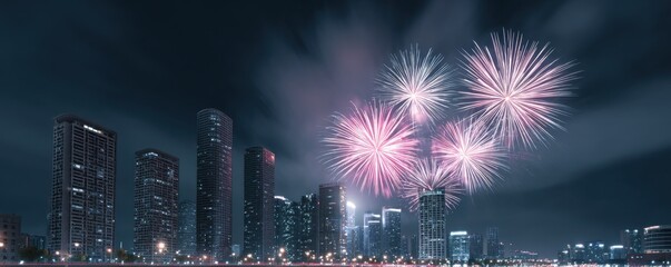 Obraz premium Colorful fireworks illuminate a city skyline at night, with tall buildings and a clear sky creating a vibrant urban scene