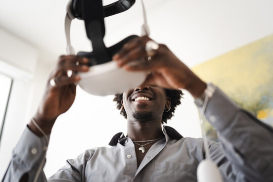 A smiling man holds a virtual reality headset, ready to experience immersive digital worlds.