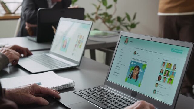 Close up shot of mock social media pages on laptop screens of unrecognizable senior people sitting at desk in row in computer literacy class, copy space