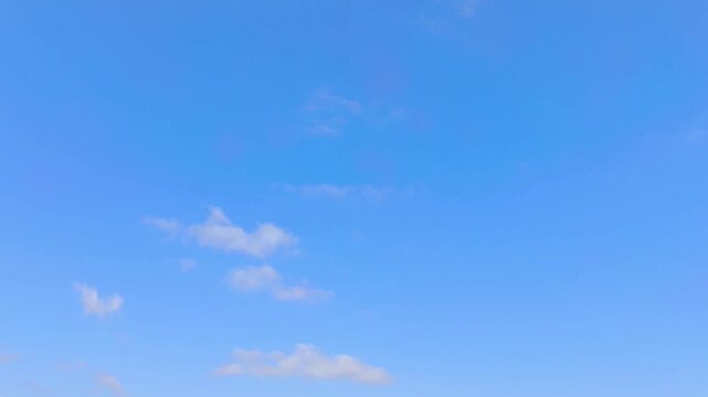 Little clouds moving in the light blue sky