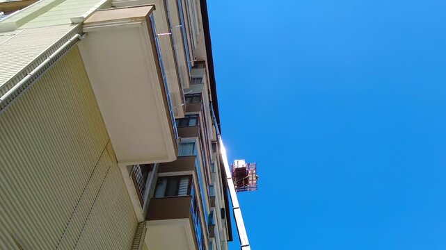 Large items are lowered and raised using a mobile elevator into apartments in multi-story buildings.