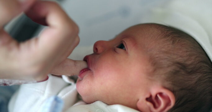 Little newborn infant suckling finger feeding