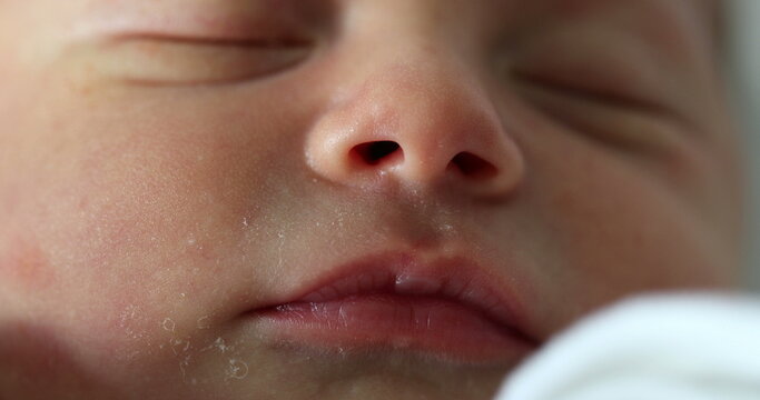 Newborn baby face closeup with eyes closed sleeping