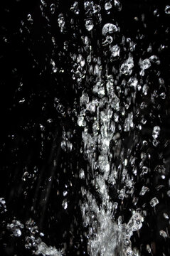 Water splashes in a dark setting during nighttime, creating a dynamic visual effect