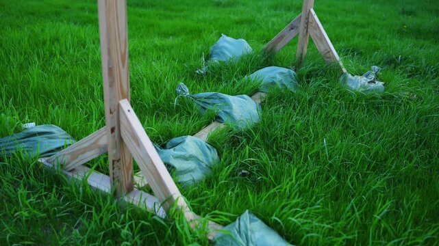 Wooden supports stabilized with sandbags on grass. Outdoor construction setup and temporary structure reinforcement.