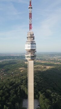 Cinematic drone reverse flight discovering Avala Tower and green nature under blue sky, Belgrade, Serbia.