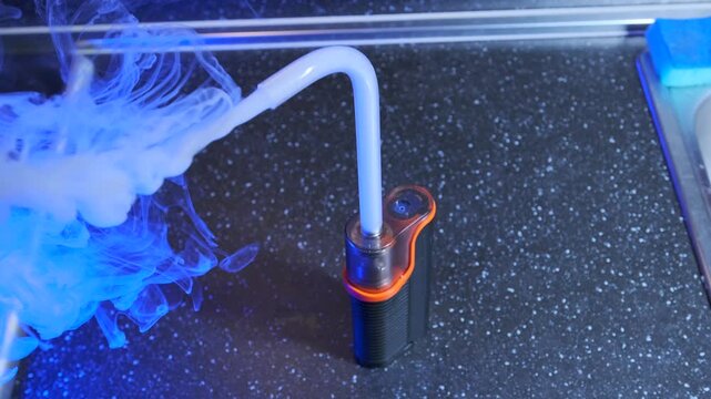 portable smoke machine working close-up view, vapor flowing through tube from device outlet, demonstrating operation, airflow mechanics, special effects equipment used for filming and stage production
